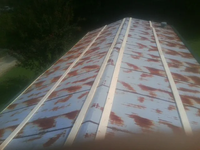 Rusted metal roof panels with new wood purlins before replacement — Storm Damage Roof Repair in Riverbank by Roofing Brothers