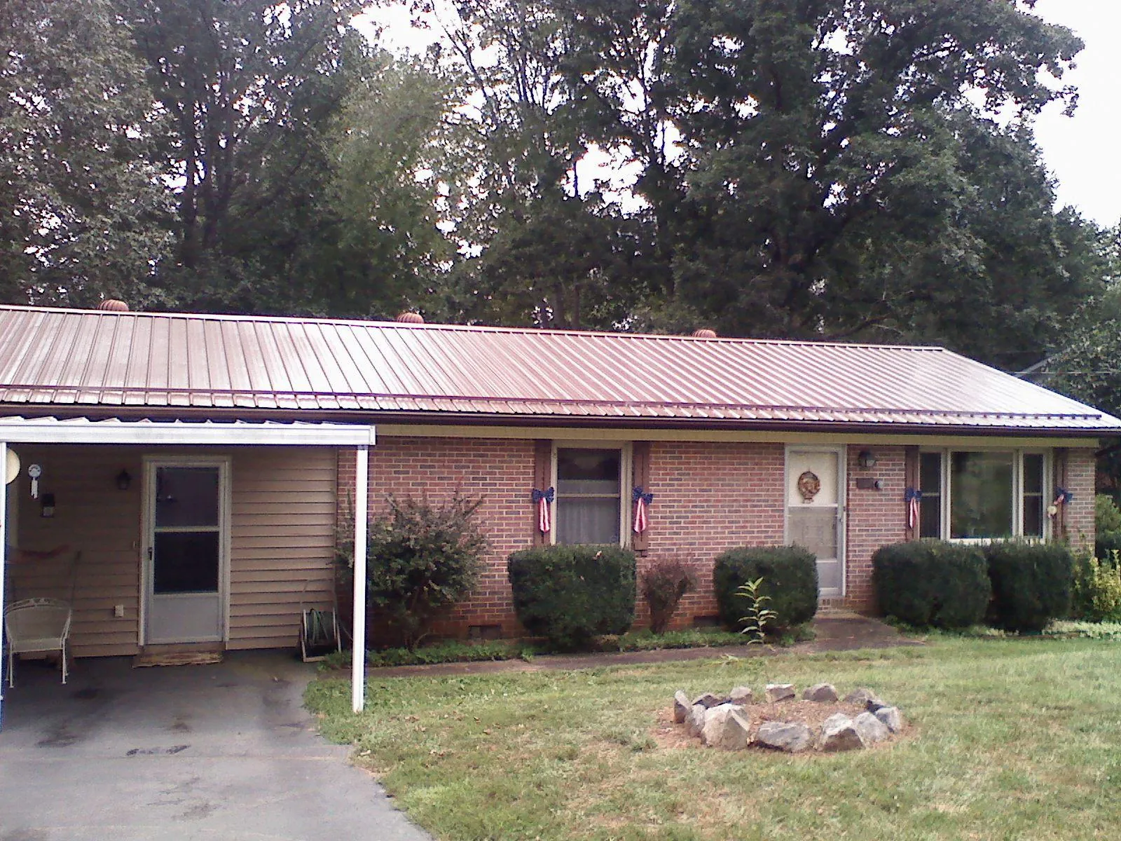 Bronze metal roof and carport on a brick ranch home — Roof Repair work by our crew in Riverbank