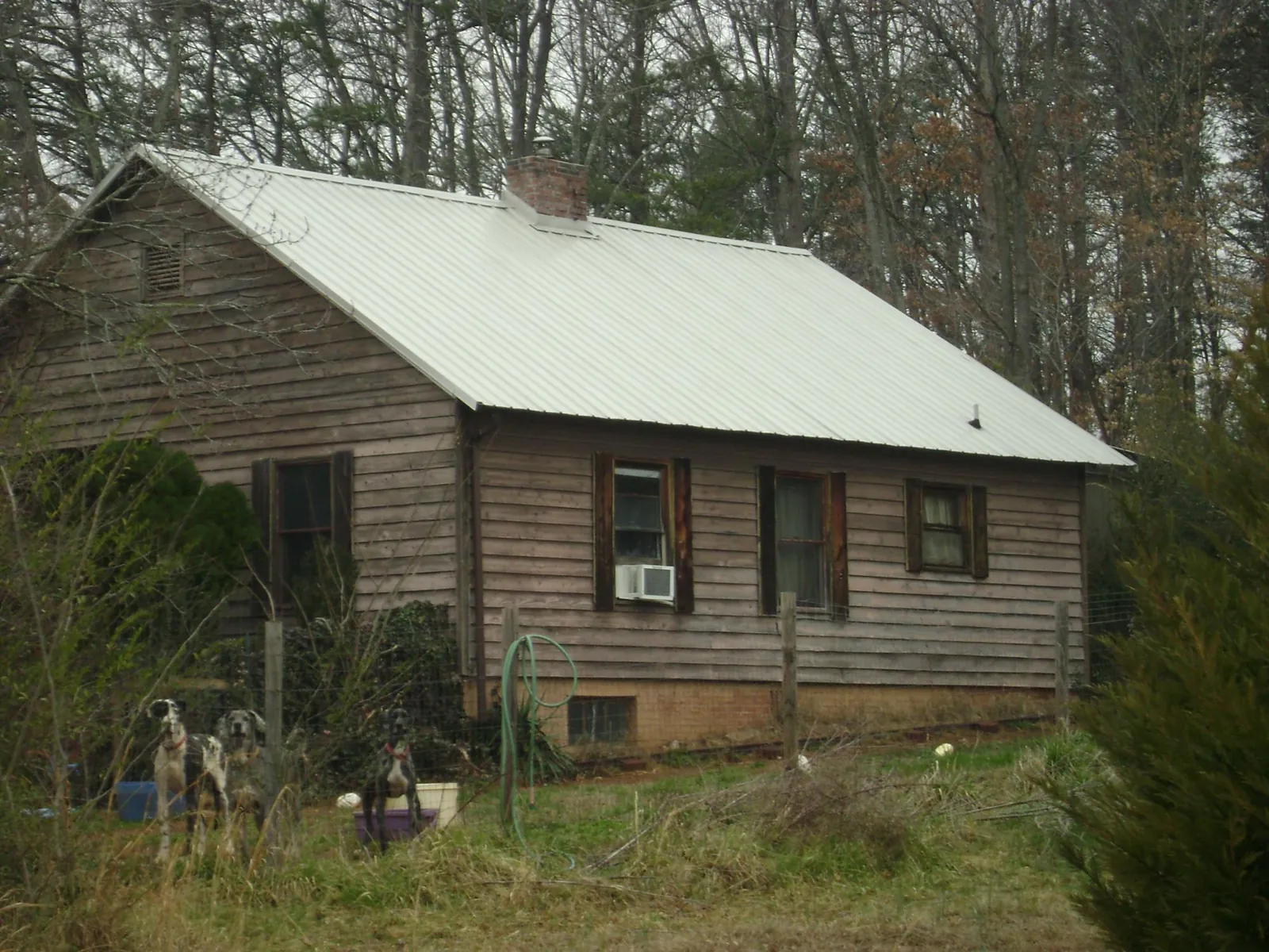 White metal roof on an old wood sided farmhouse, from a Metal Roof Installation job in Riverbank